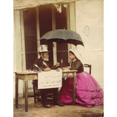 'La Scrivano'. Italian public letter writer, seated at table with young lady under umbrella.
